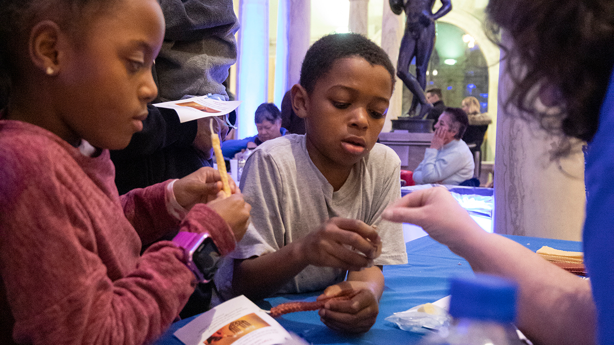 Children share art supplies during an art-making activity at the museum.
