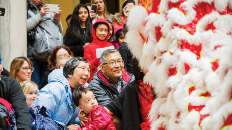 Family and children watch the dragon dance during Lunar New Year celebration on the sculpture court.