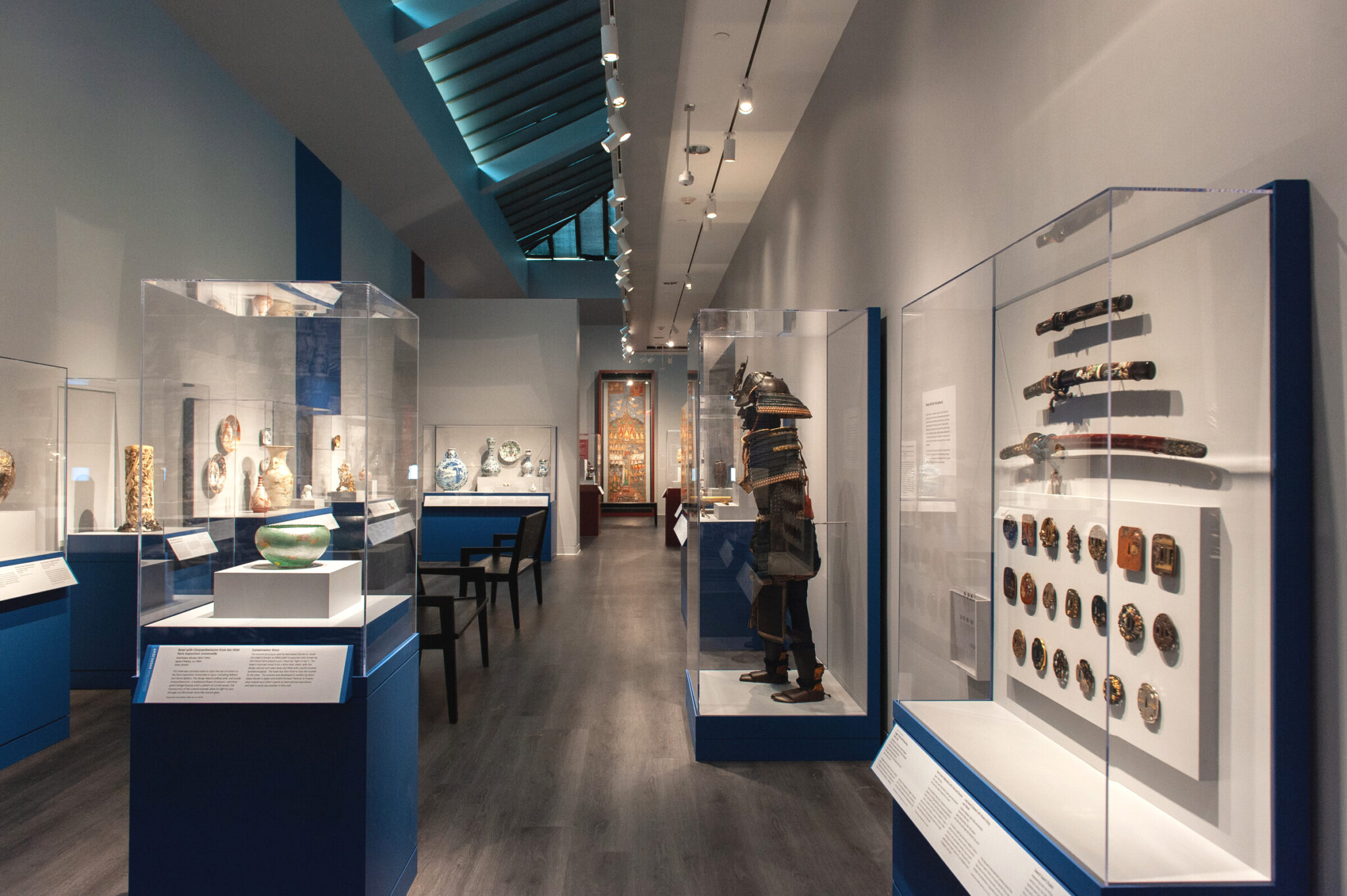 Many art objects in cases in a long gallery