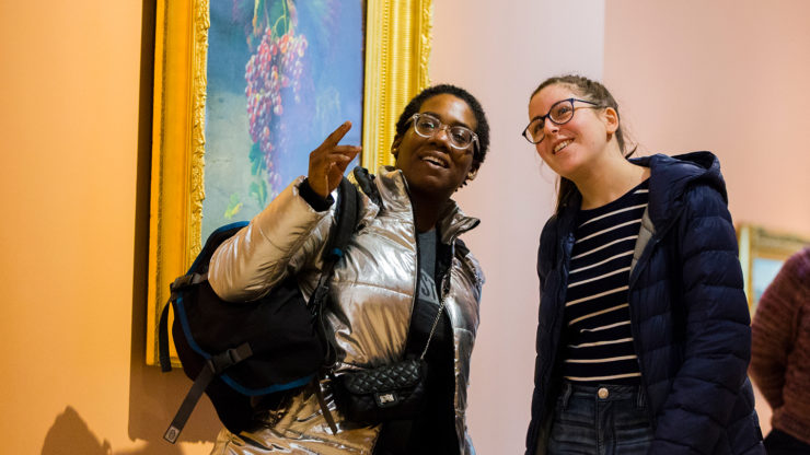 College students conversing in a museum gallery.