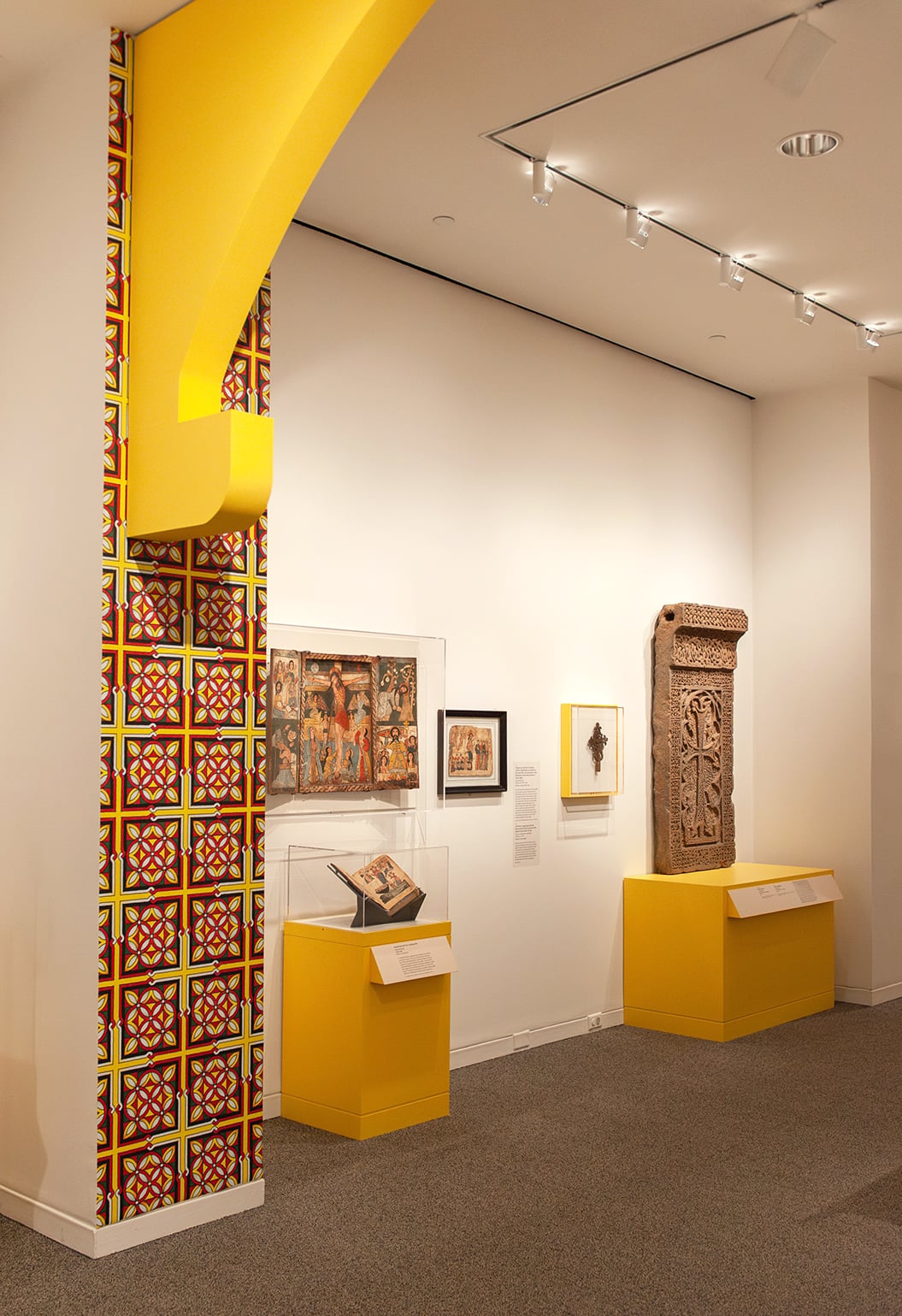 An in-gallery view of art objects and a patterned wall graphic in Ethiopia at the Crossroads