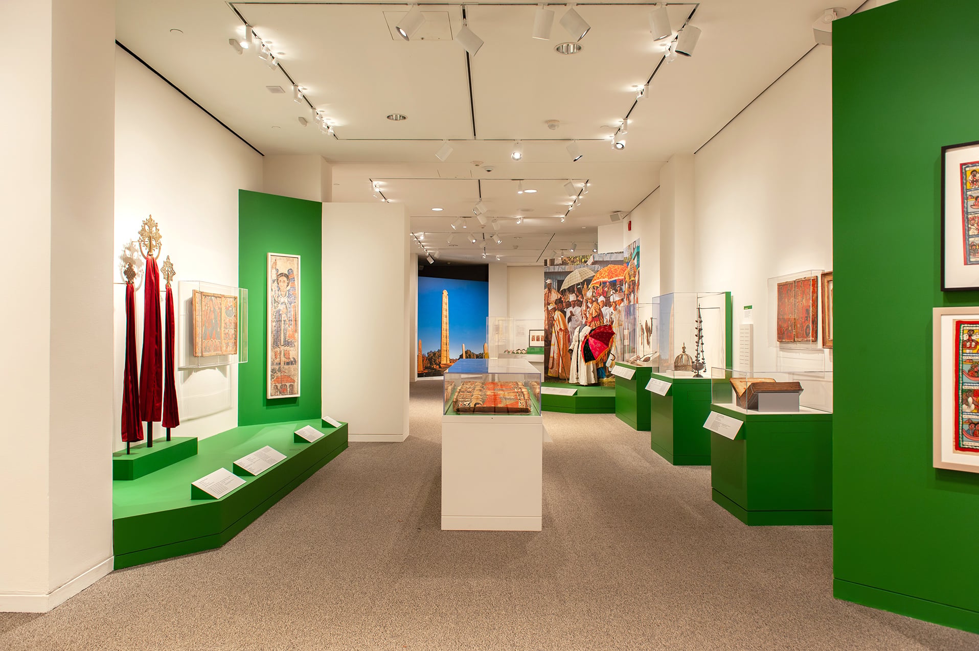 An in-gallery view of art objects and a large wall graphic in Ethiopia at the Crossroads