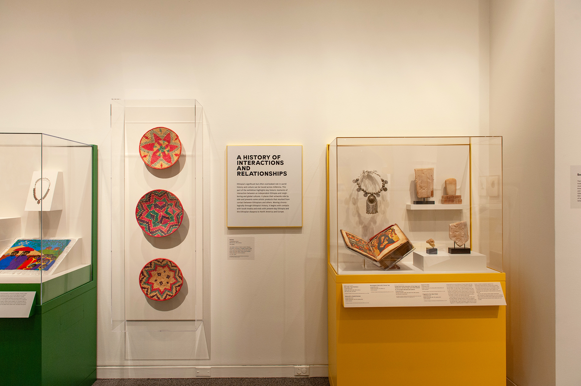 An in-gallery view of art objects and a wall text in Ethiopia at the Crossroads