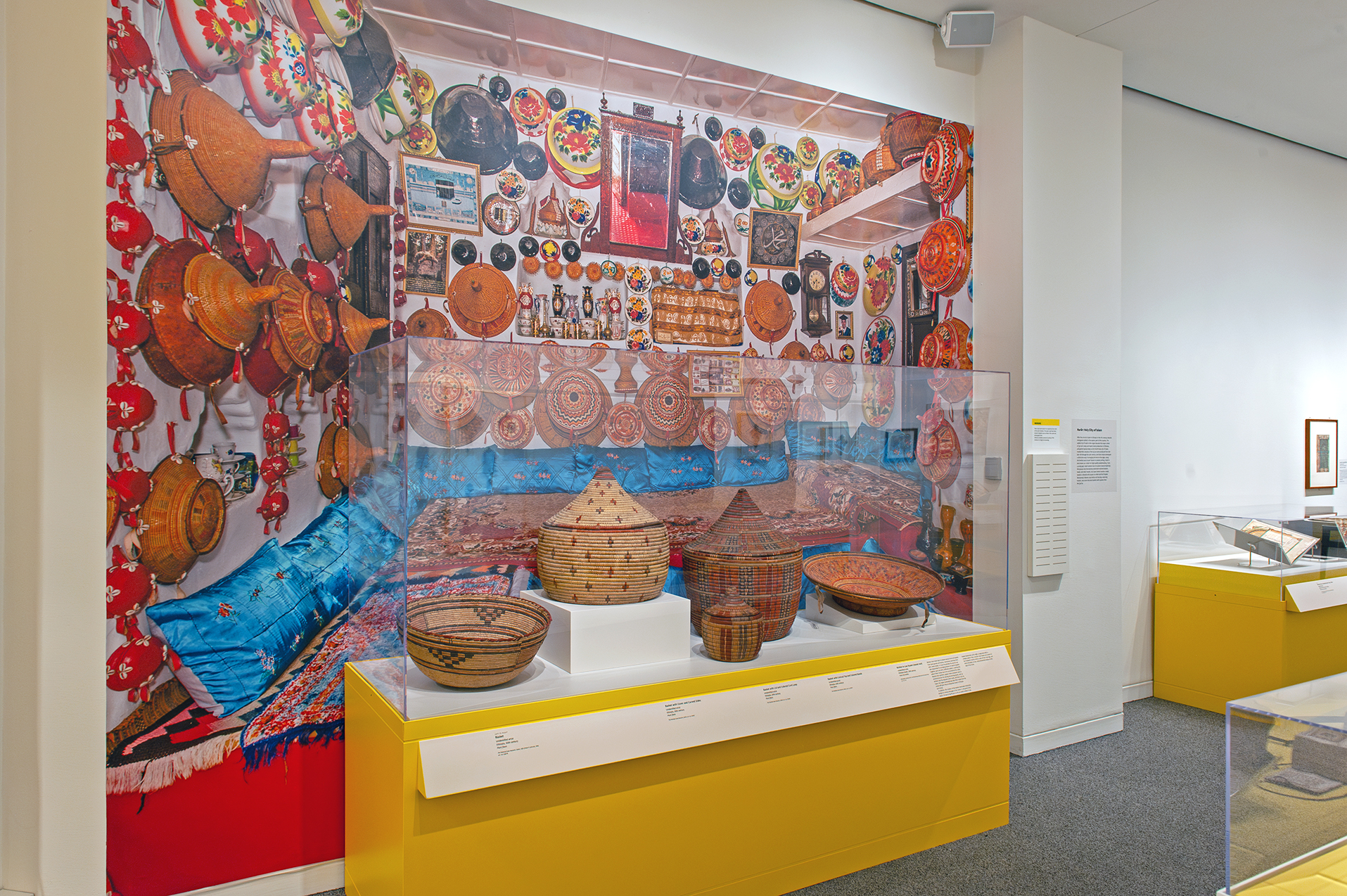 An in-gallery view of art objects and a large photo graphic in Ethiopia at the Crossroads