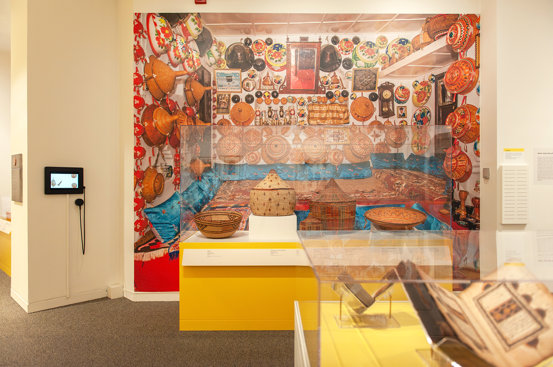An in-gallery view of art objects and a large photo graphic in Ethiopia at the Crossroads