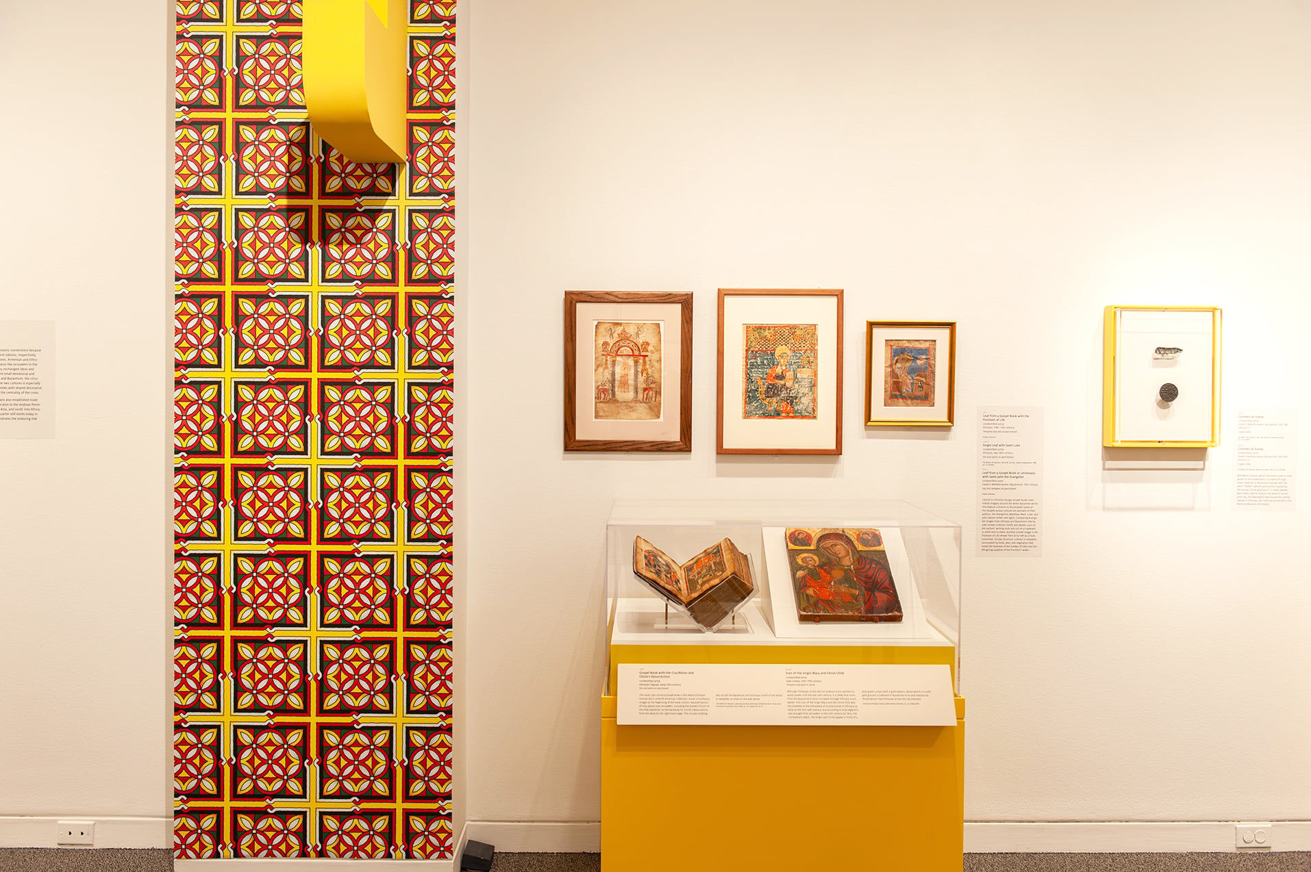 An in-gallery view of art objects and a patterned wall graphic in Ethiopia at the Crossroads