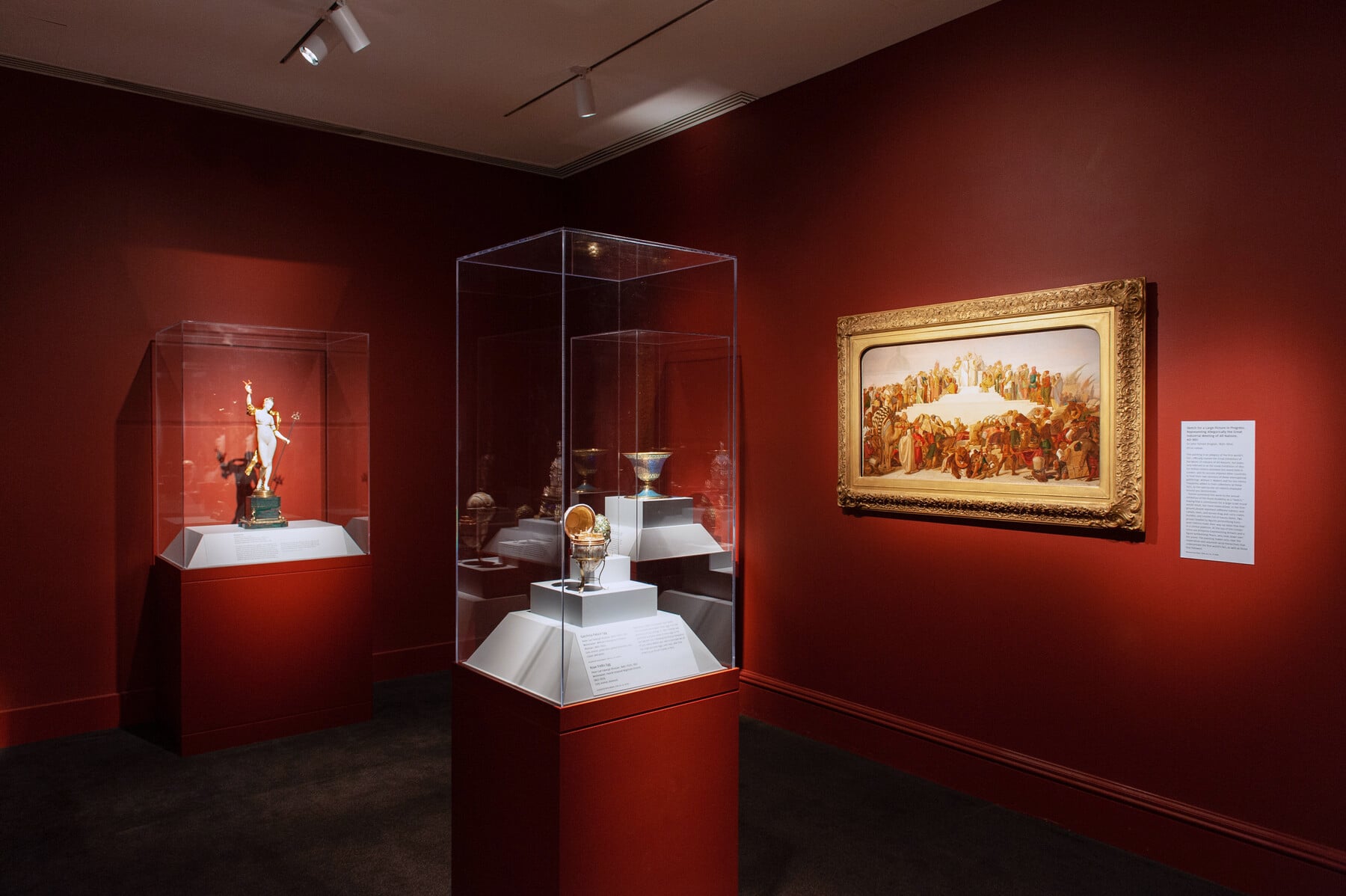 An in-gallery view of Distinctive Design with several cases of art objects and a painting on the wall
