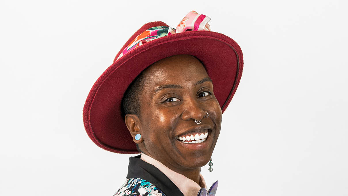 Unique Mical Robinson smiling, wearing a red hat