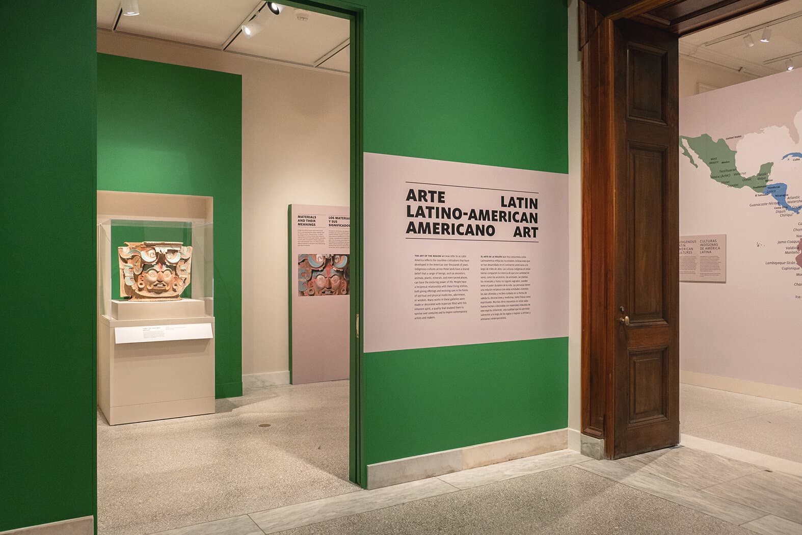 In the gallery looking toward the title wall for the installation Latin American Art / Arte Latinoamericano