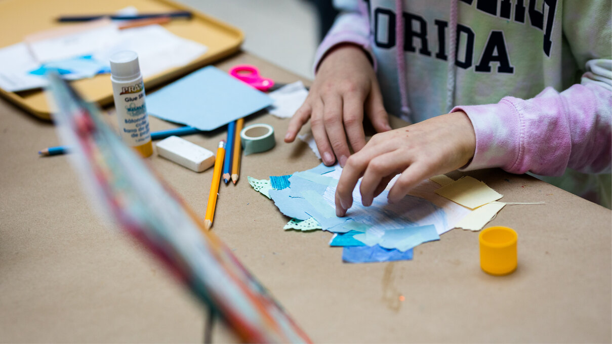 detail of hands, working on a collage
