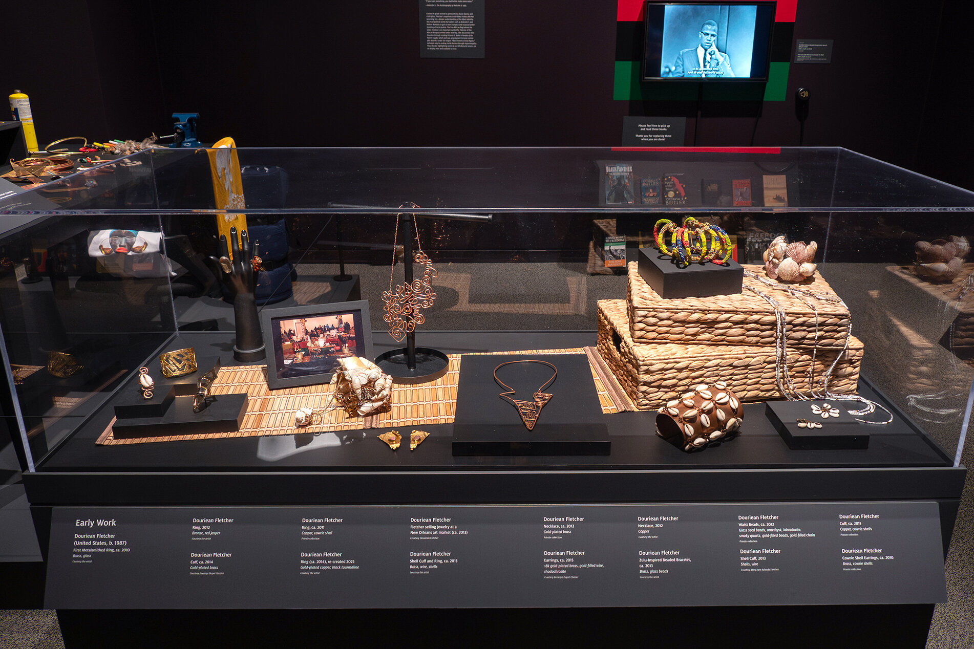 Jewelry on display in a case in the exhibition Douriean Fletcher: Jewelry of the Afrofuture
