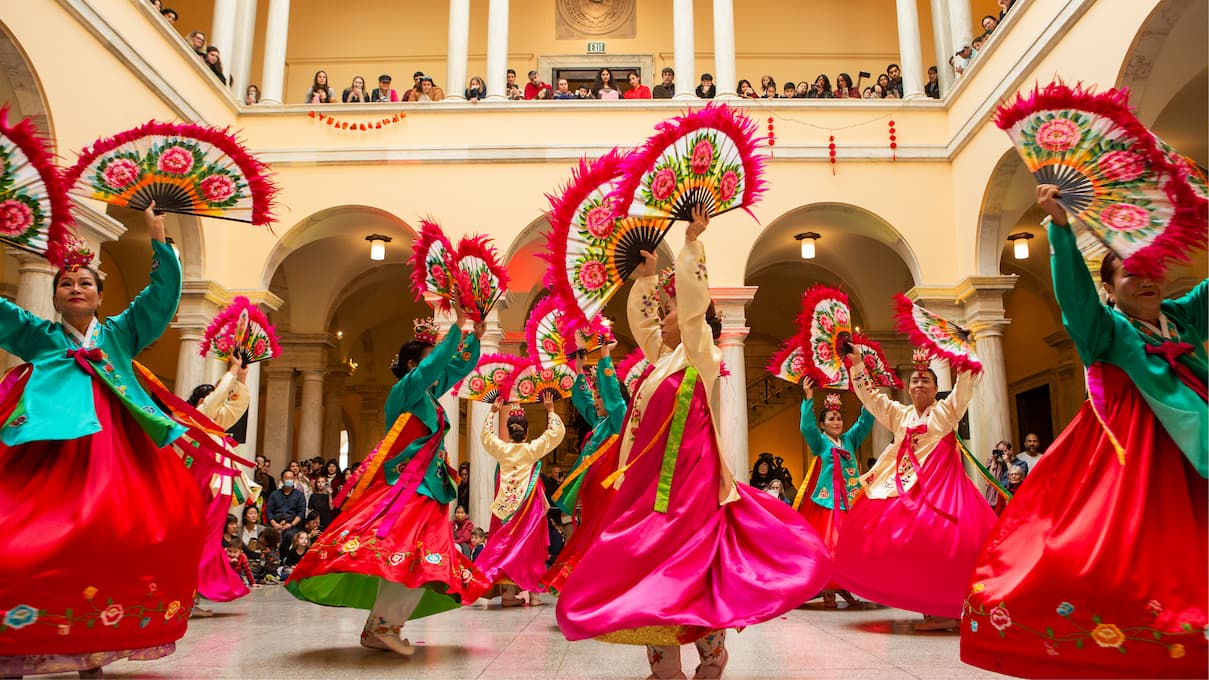 dancers in colorful costumes for lunar new year, waving large fans