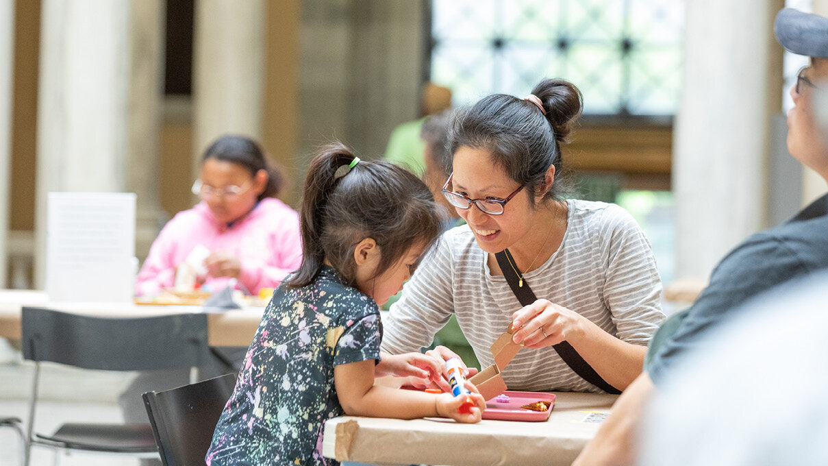 adult and child making art together on the sculpture court
