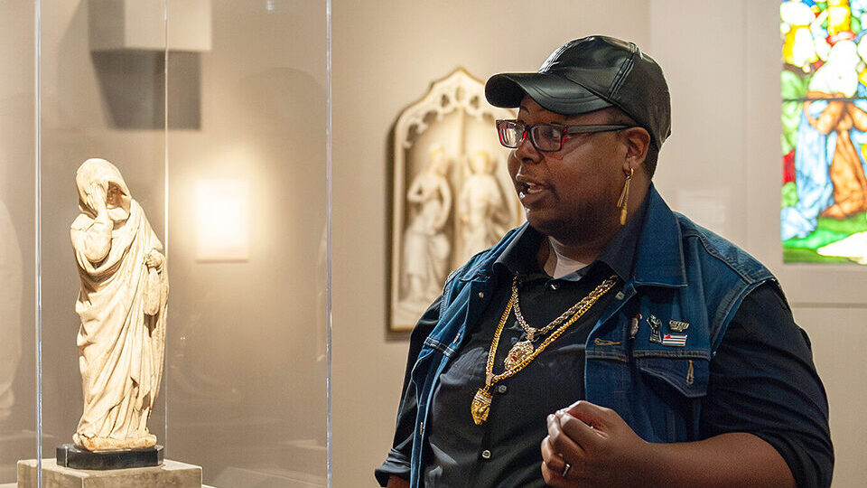 A visiting artist speaks in a gallery for Queering the Collection