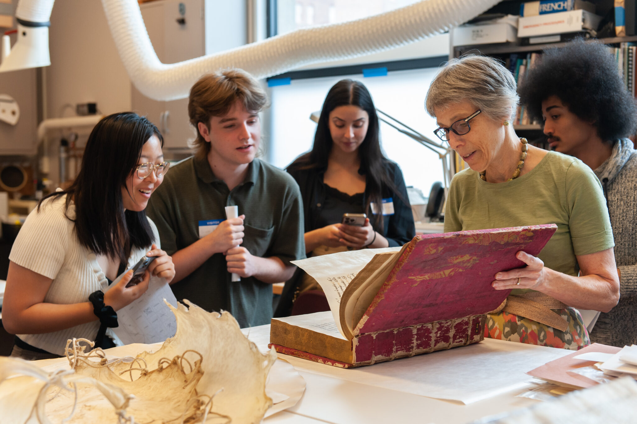 Visiting college students are shown a manuscript by a Walters Art Museum conservator