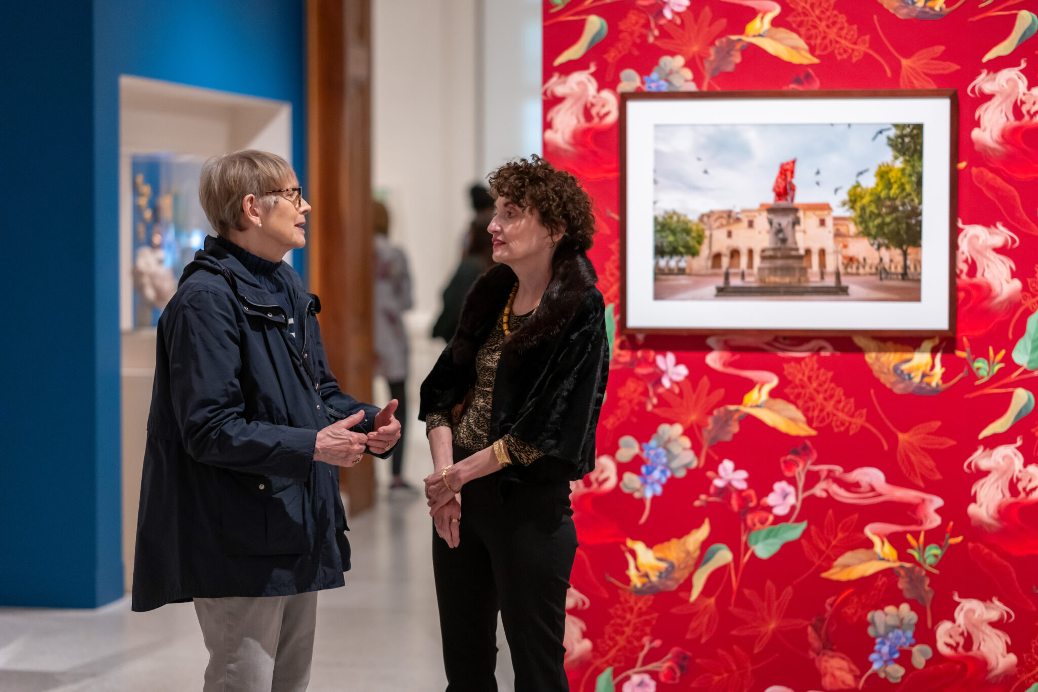 Two visitors talk in a gallery
