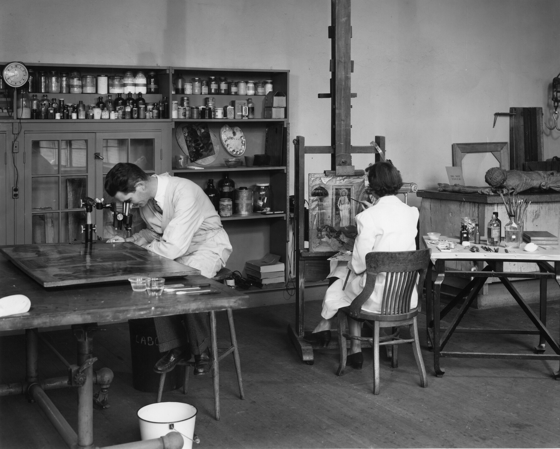 A historical photo of conservators Jack Kirby and Elisabeth Packard working in the Conservation Lab