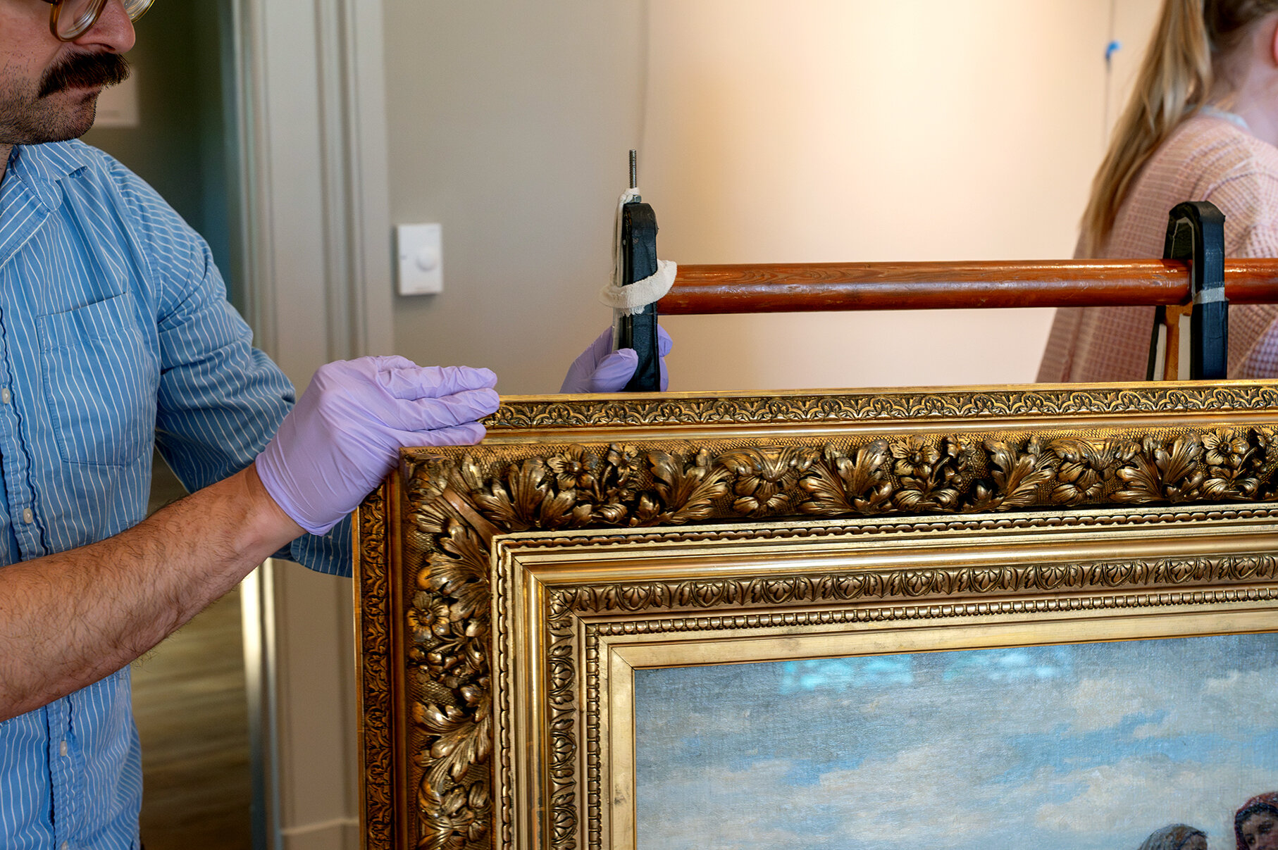 An art handler safely moves a painting