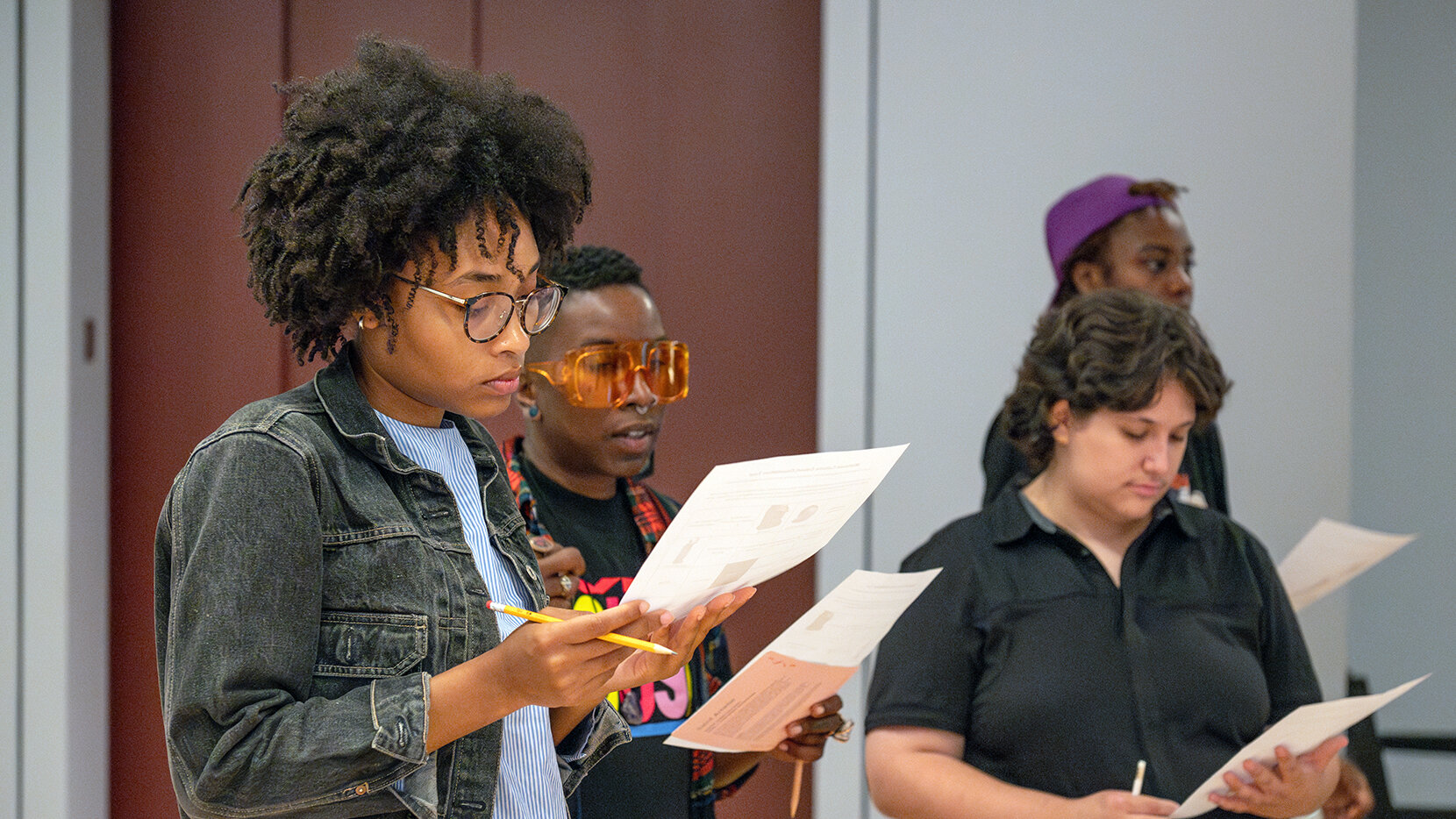 College students look at handouts in a gallery