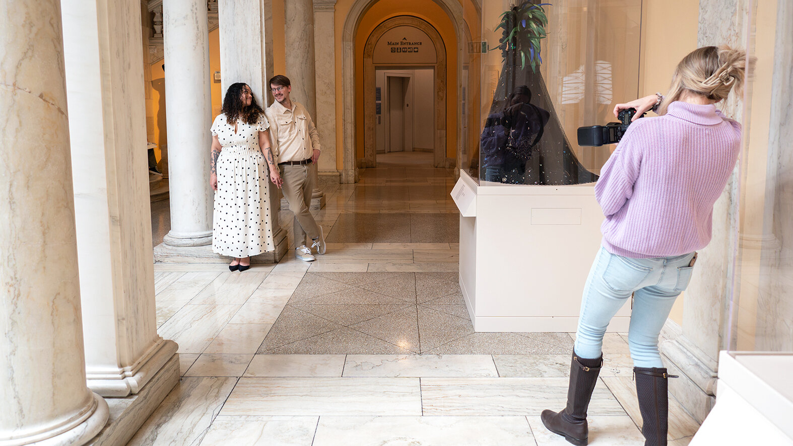 A visitor takes a photo of a couple on the Sculpture Court