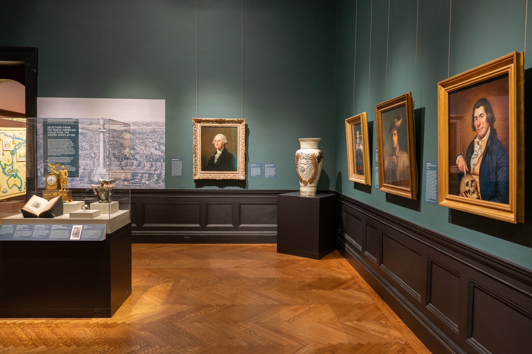 Gallery view of the United States at 250 with paintings and a vase