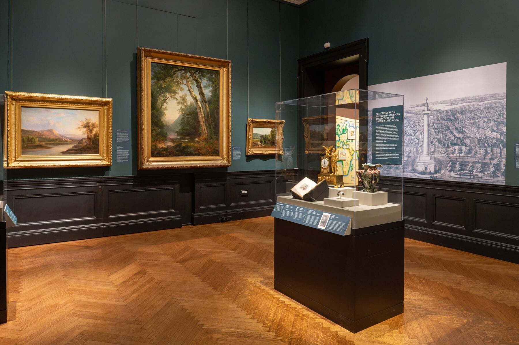 Gallery view of the United States at 250 with paintings and a case with art objects