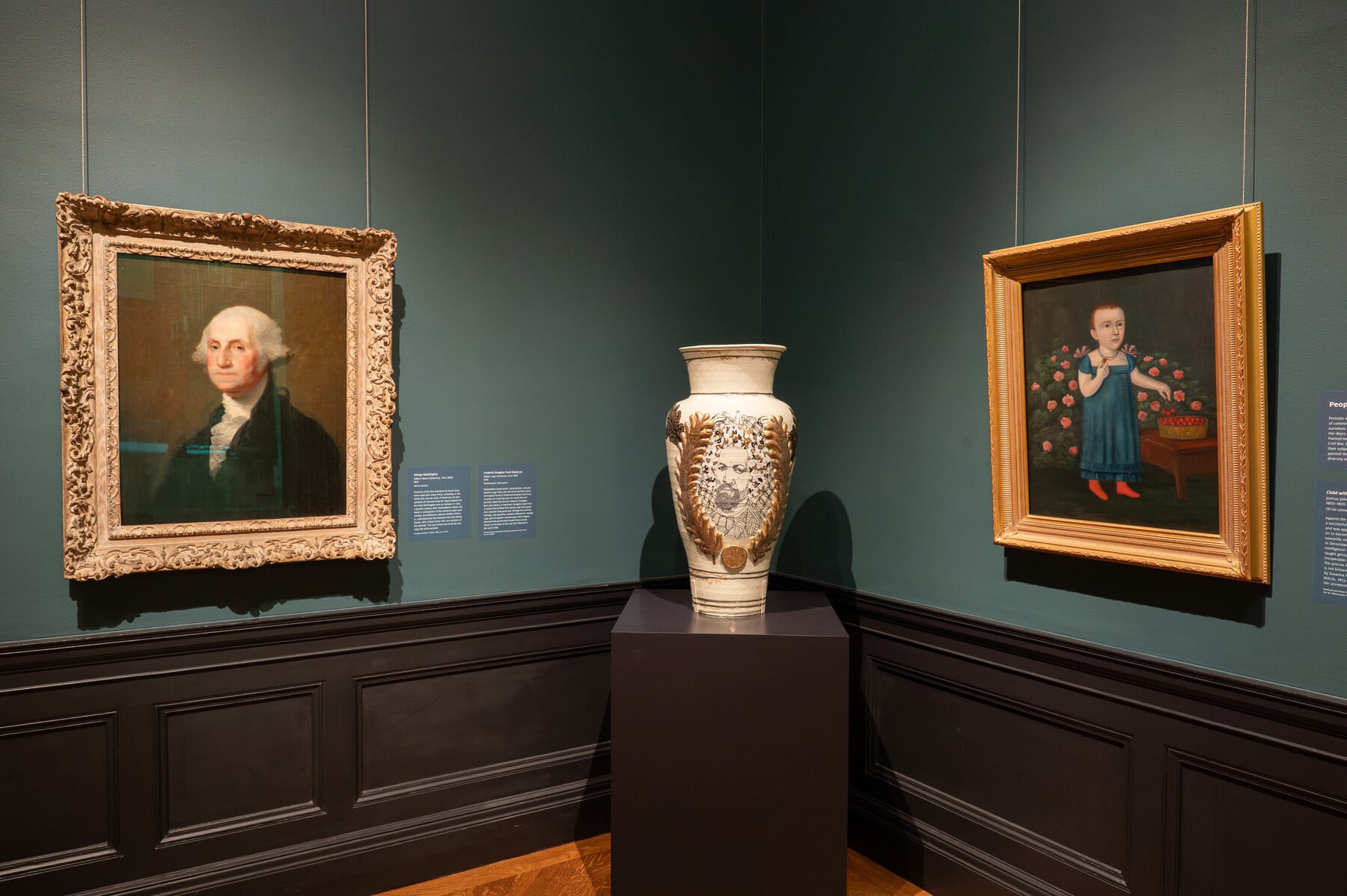Gallery view of the United States at 250 with paintings and a vase