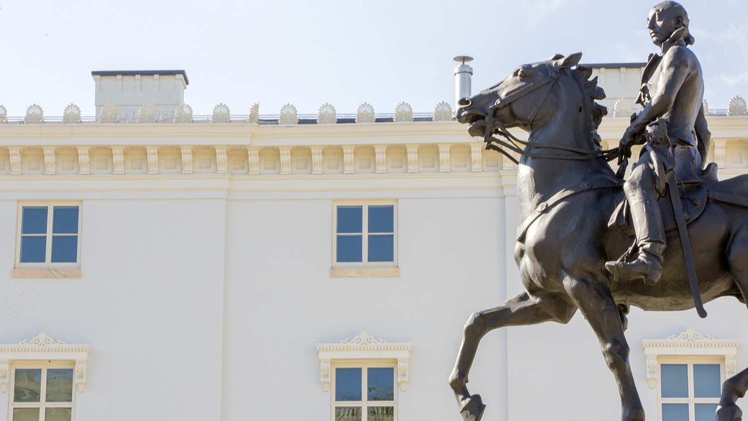 In the Mount Vernon neighborhood, a view of the bronze statue of Lafayette with One West Mount Vernon Place in the background
