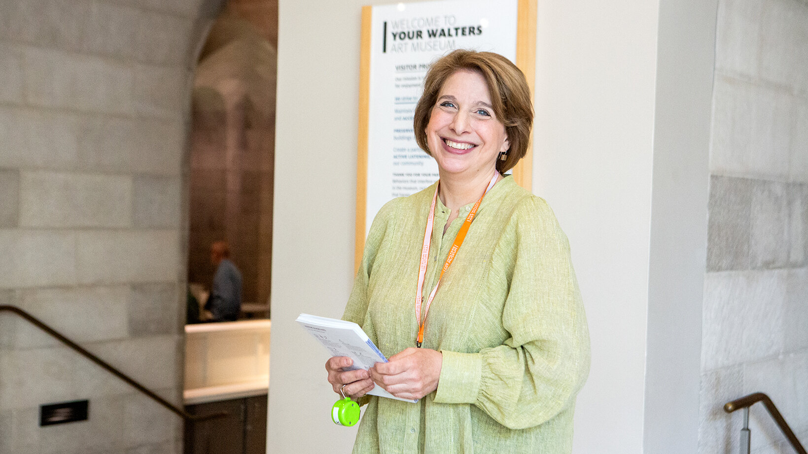 A volunteer smiles near the entrance of the Walters Art Museum