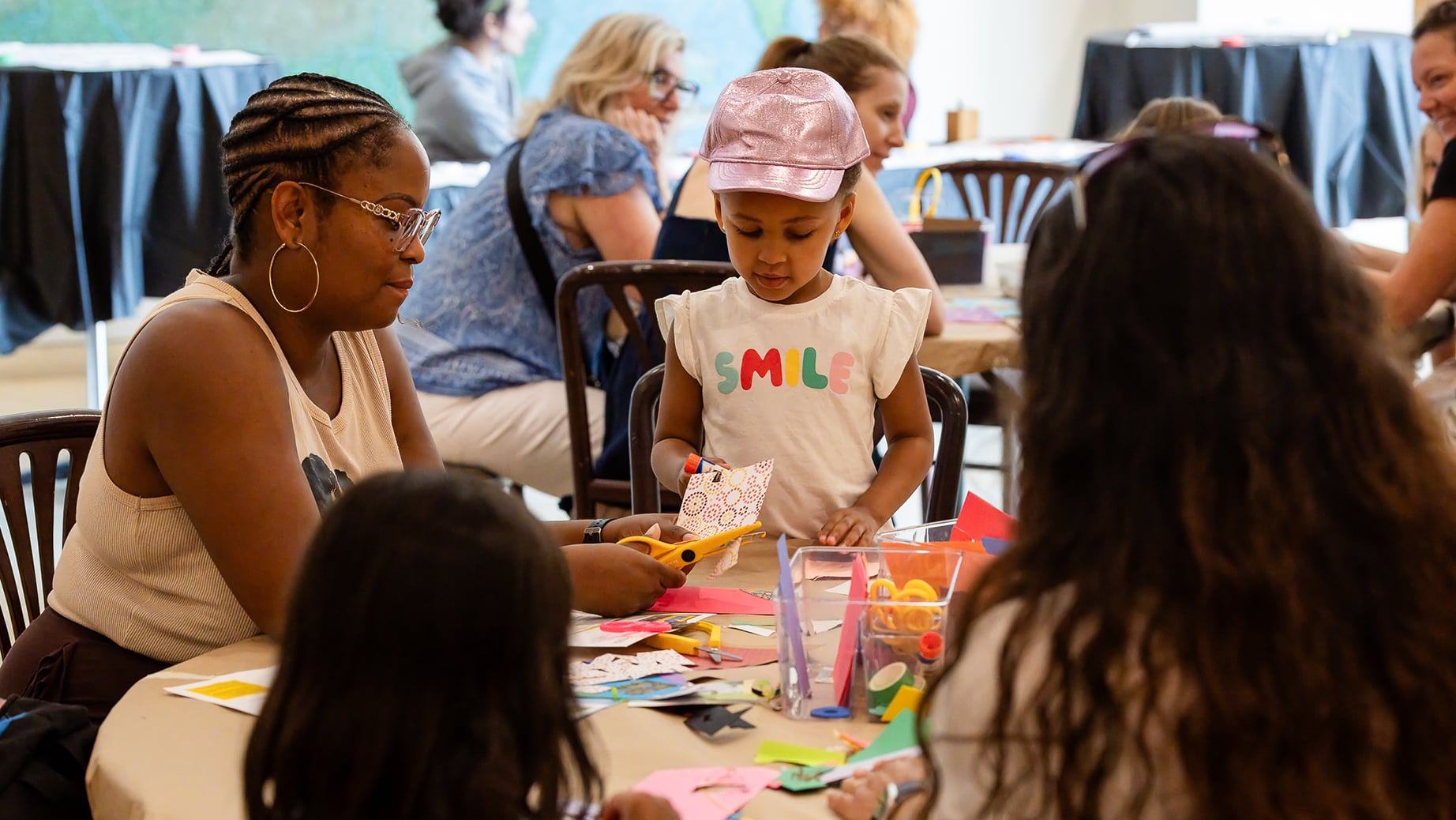 A family sits and uses art making supplies at a museum event