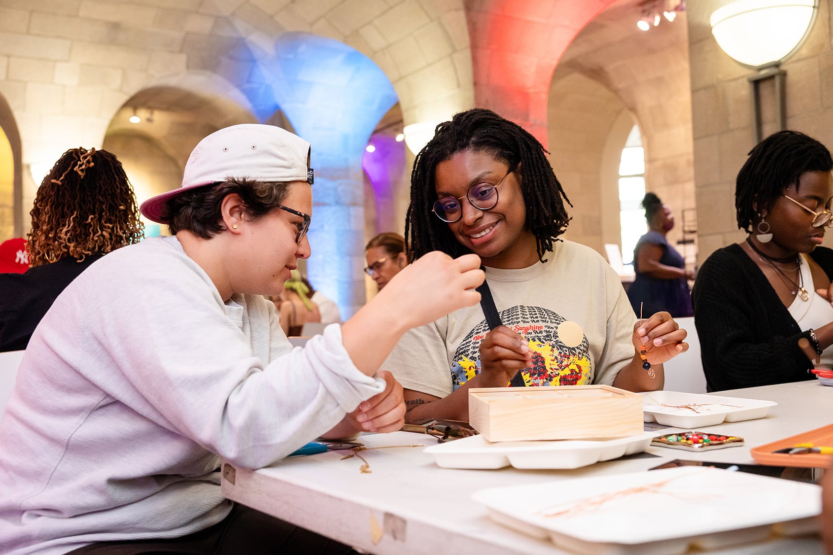 Visitors participate in a jewelry making workshop in the museum's cafe